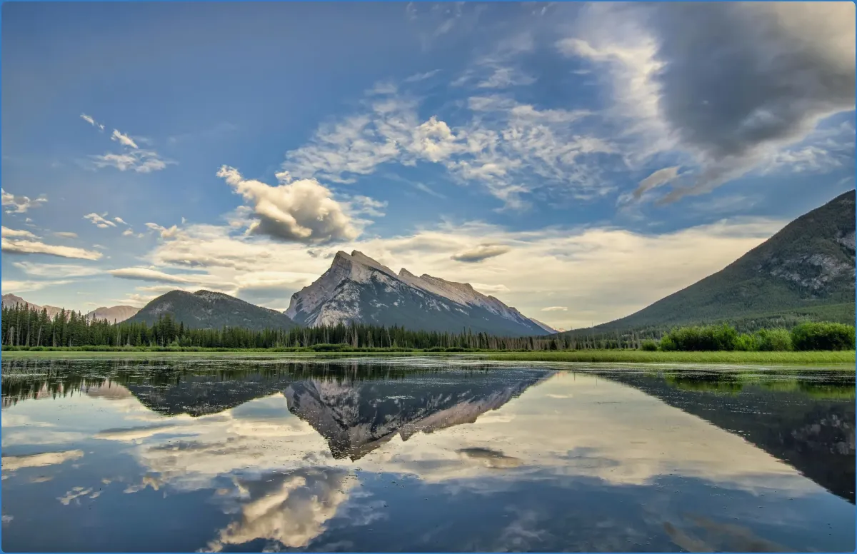 Mountain reflected in a calm lake under a blue sky.