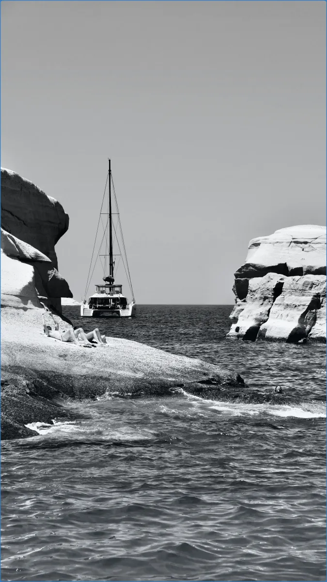 Sailboat between rocky cliffs on the sea.