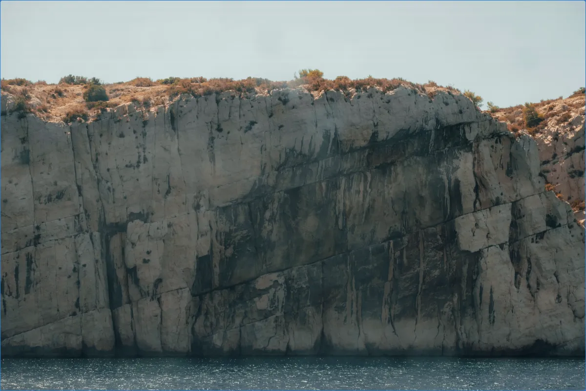 Cliff face with sparse vegetation above