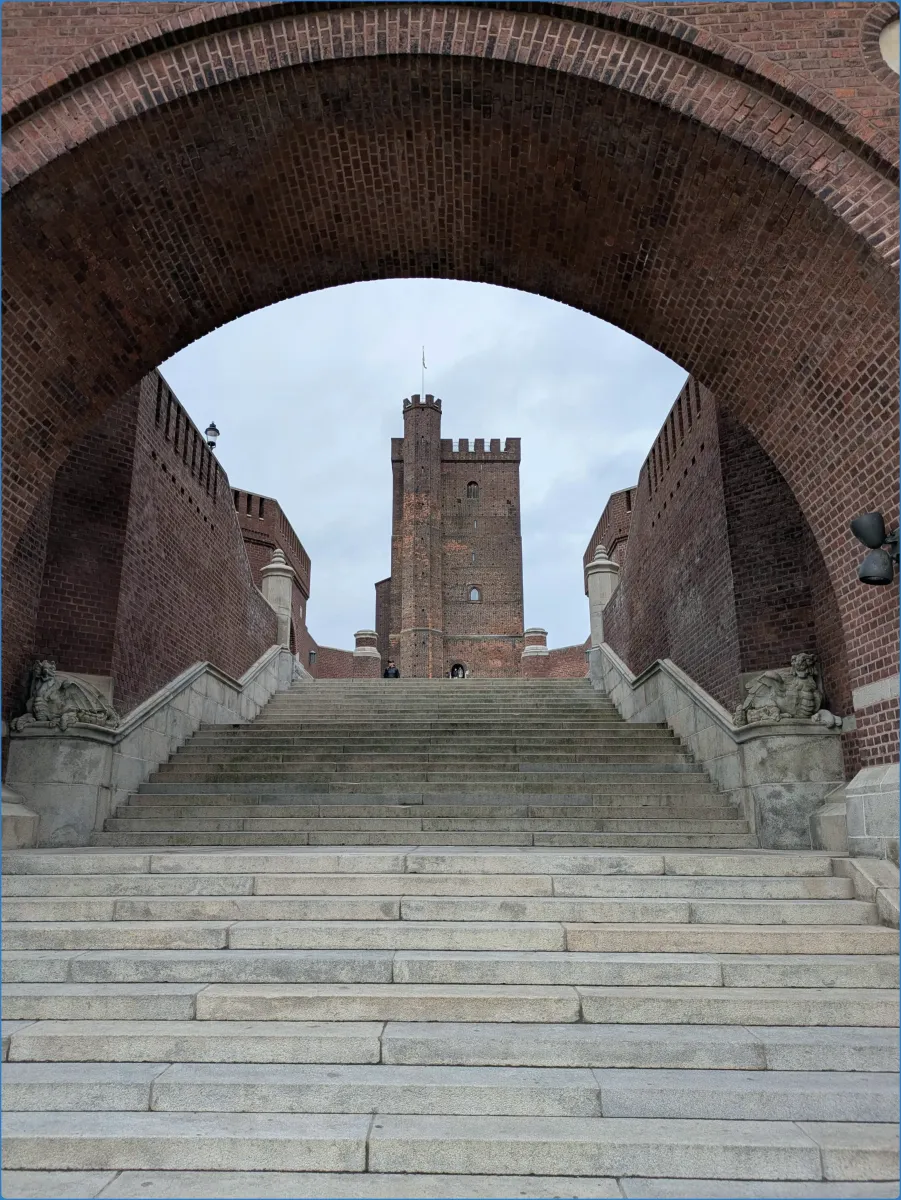 Stone staircase leading to a brick tower under an archway
