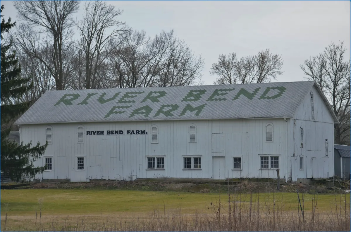 White barn with 'River Bend Farm' on roof
