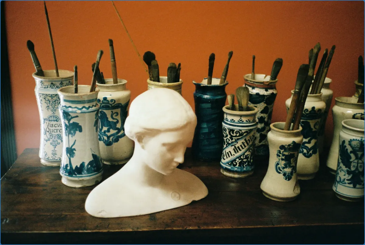 Bust sculpture with jars of paintbrushes