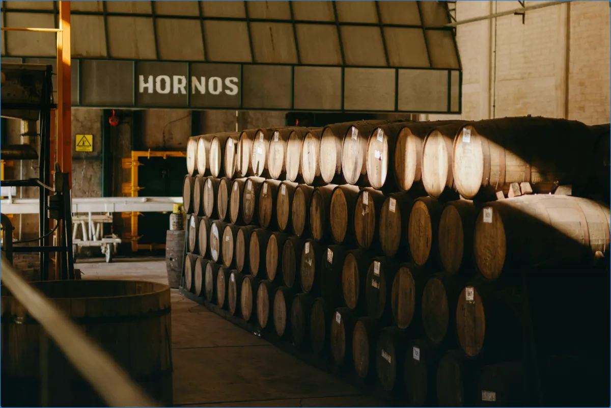 Stacked wooden barrels in a warehouse.