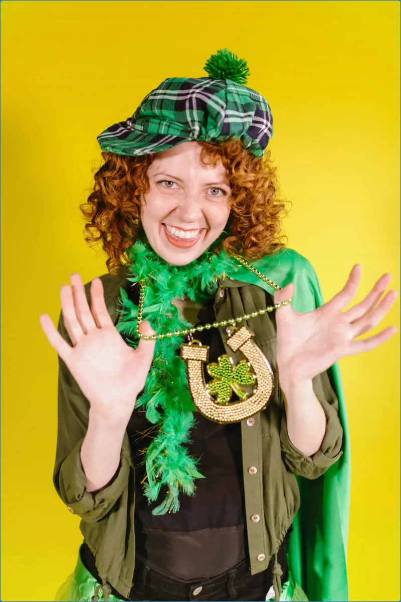 Smiling person in green attire with a shamrock necklace