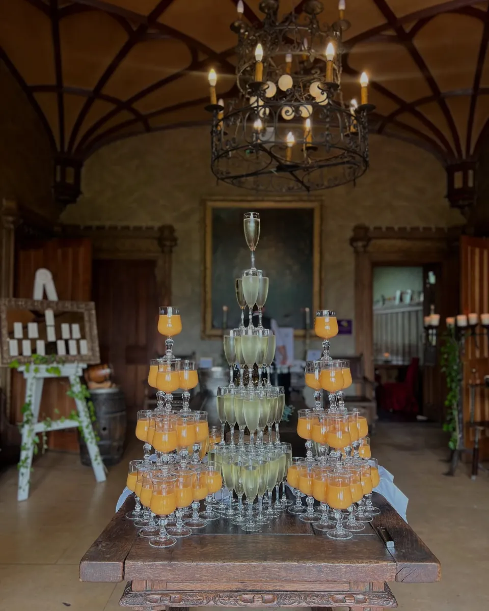 Pyramid of champagne and orange juice glasses on a table.