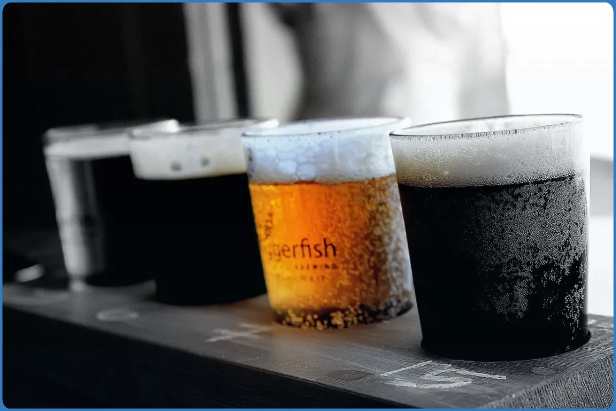Four beer glasses on a wooden surface