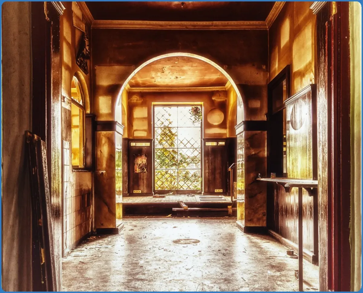 Sunlit interior of an old building with arched doorway