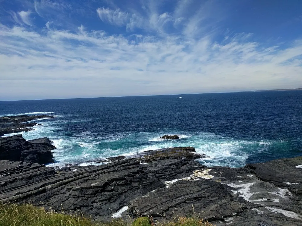 Rocky coastline with ocean waves and blue sky