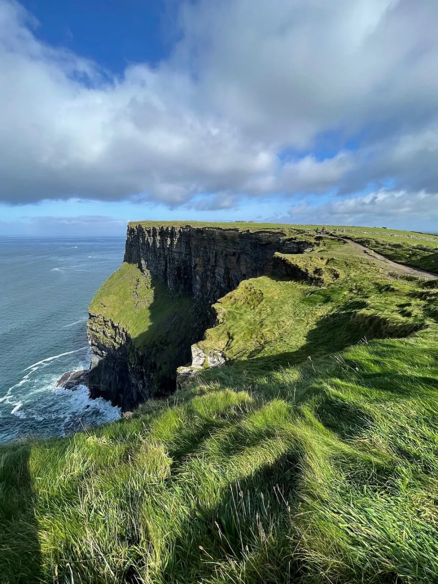 Cliffs and ocean under a partly cloudy sky