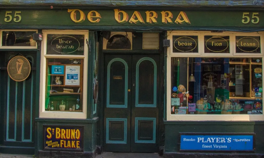 Front view of De Barra pub with green facade.