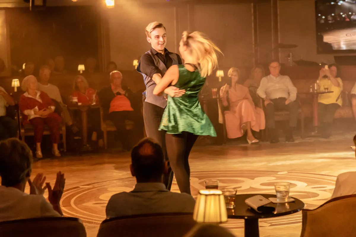 Two dancers performing in front of an audience.