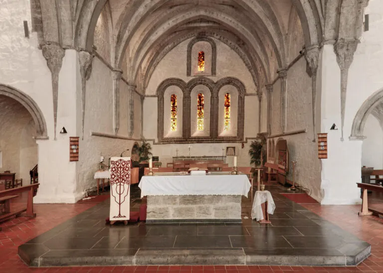 Interior of a historic church with stained glass windows.