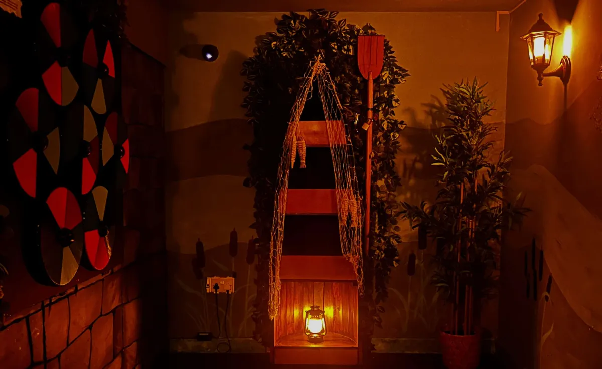 Dimly lit room with lantern, plants, and decorative items.