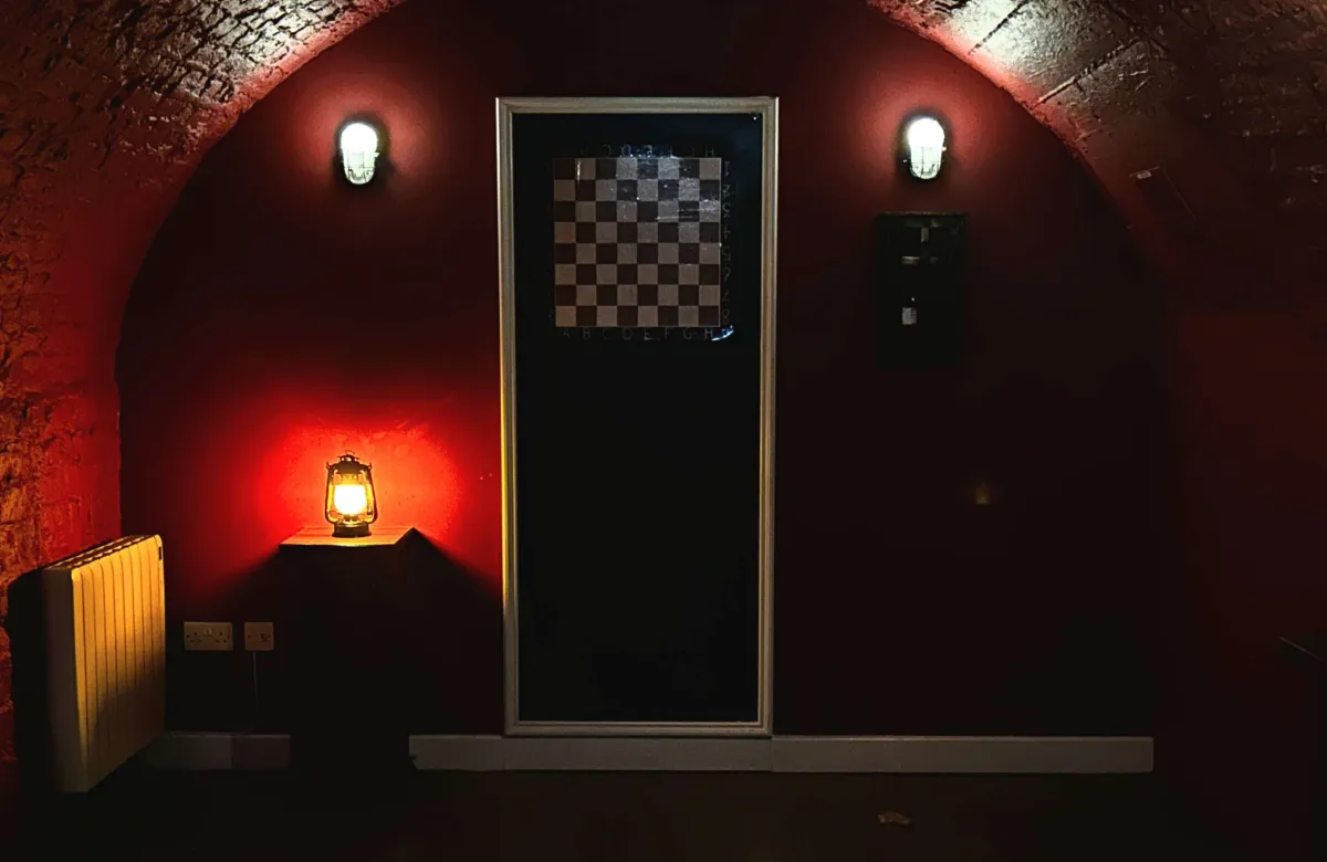 Dimly lit room with a chessboard on the door.