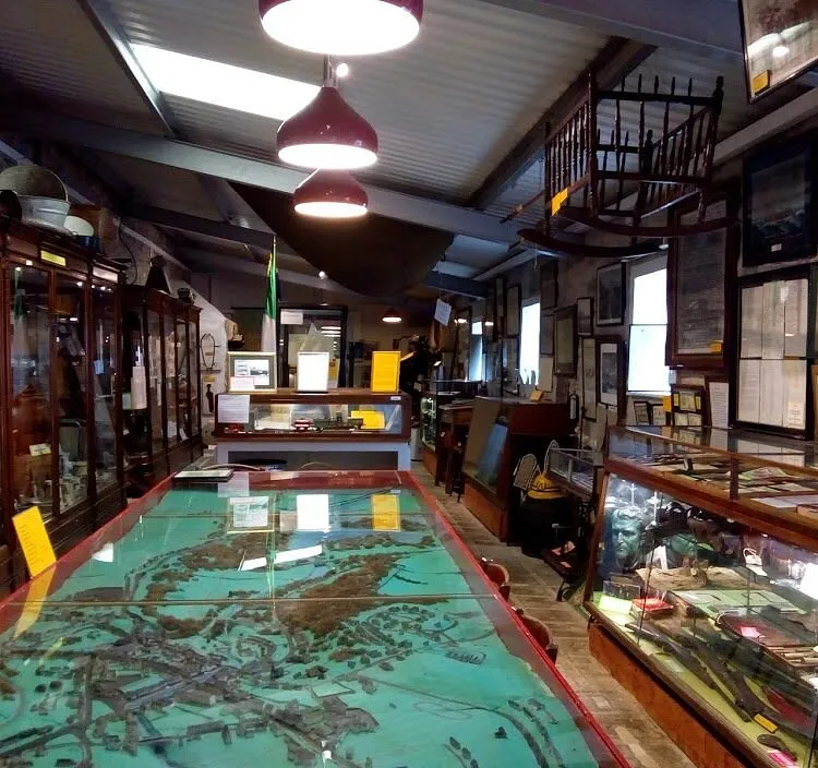 Interior of a museum with display cases and maps.
