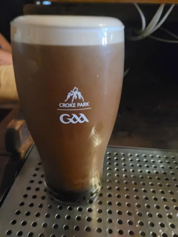 Pint of stout with Croke Park GAA logo on glass.