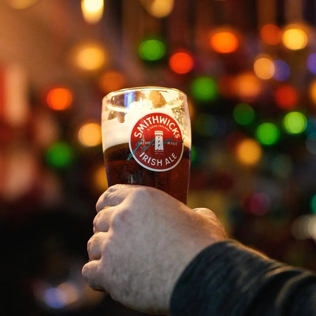 Hand holding a glass of Smithwick's Irish Ale.