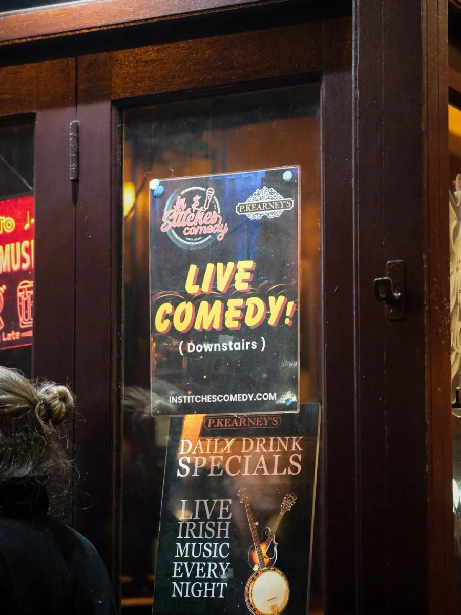 Signs for live comedy and Irish music at a venue entrance.