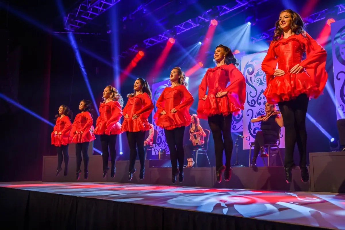 Dancers in red dresses performing on stage