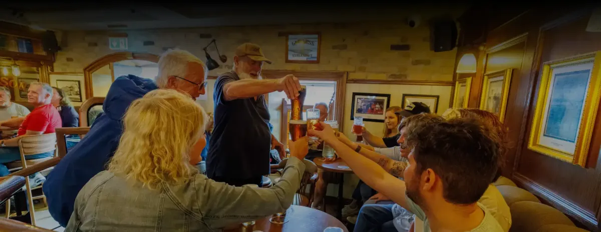 Group of people toasting with drinks in a cozy pub