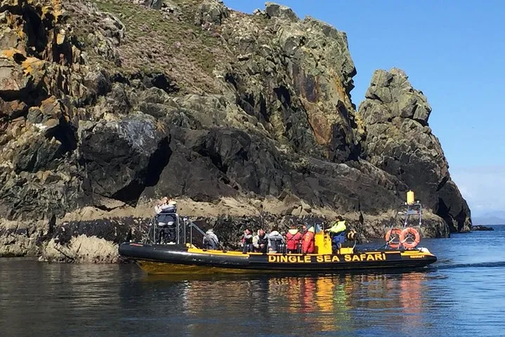 Tour boat near rocky cliffs on calm water