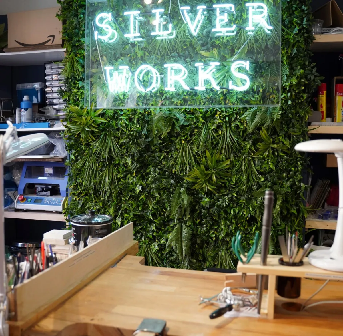 Workshop with tools and a green wall with 'Silver Works' sign.