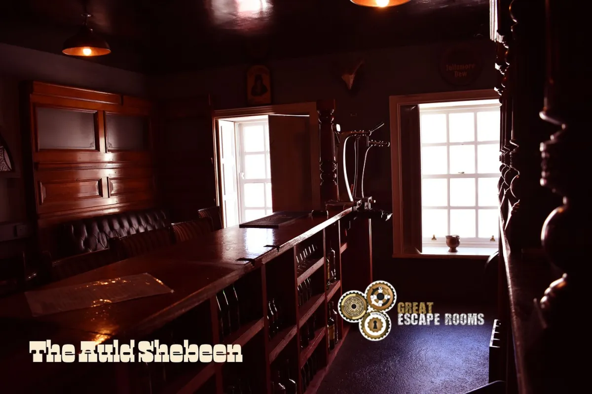 Dimly lit pub interior with wooden bar and seating.