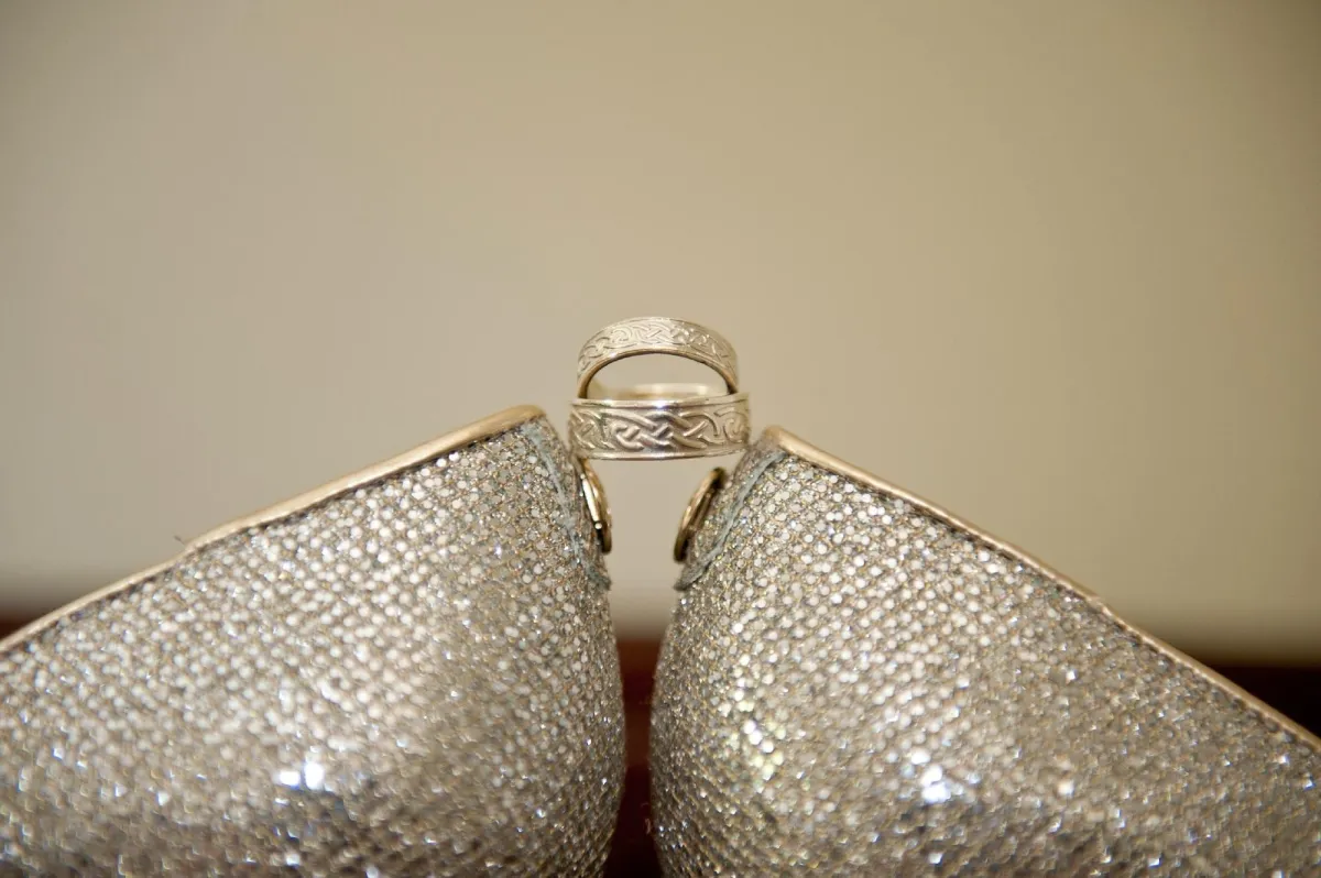Two sparkling shoes with a ring balanced on top