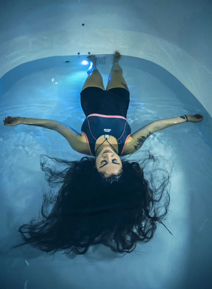 Person floating in water with eyes closed.
