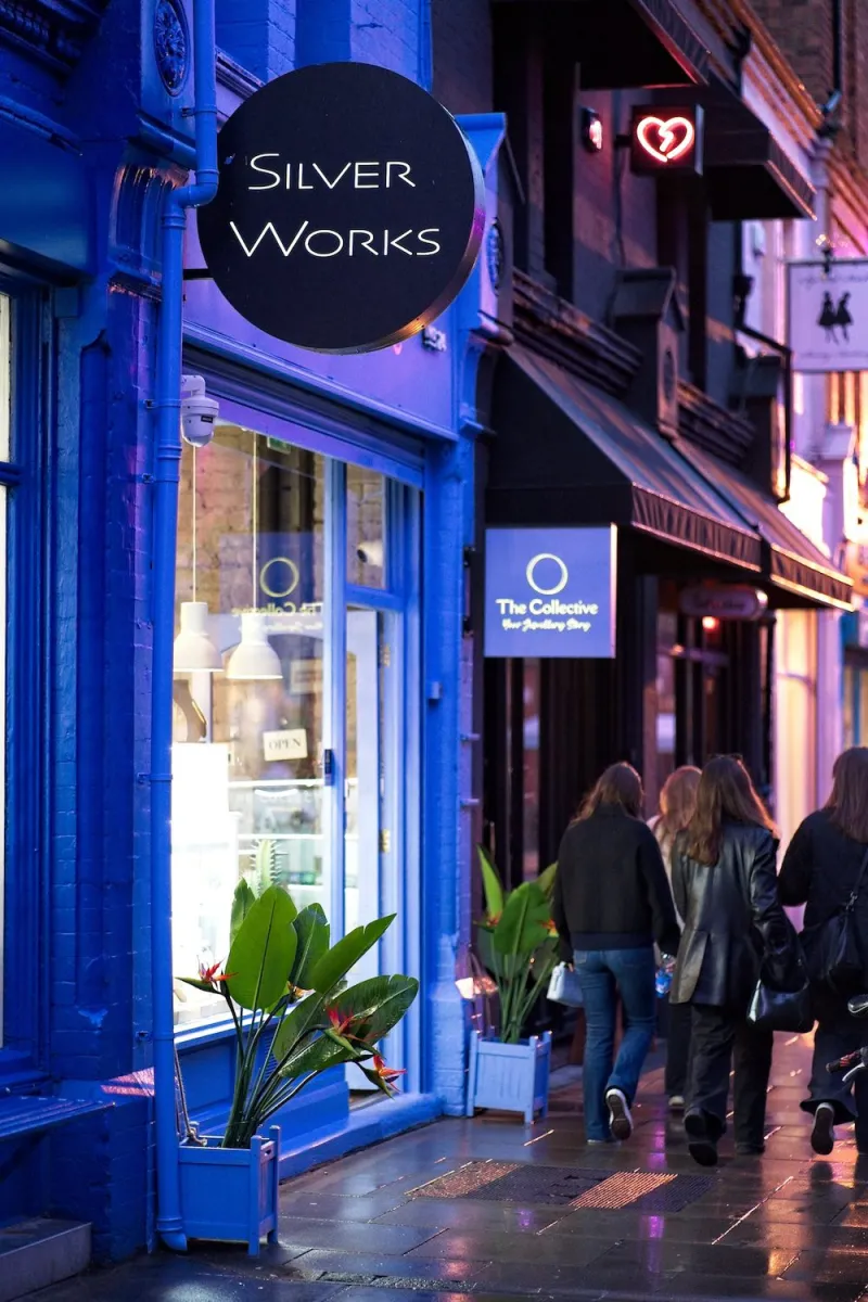 Night street view with people walking past a shop.