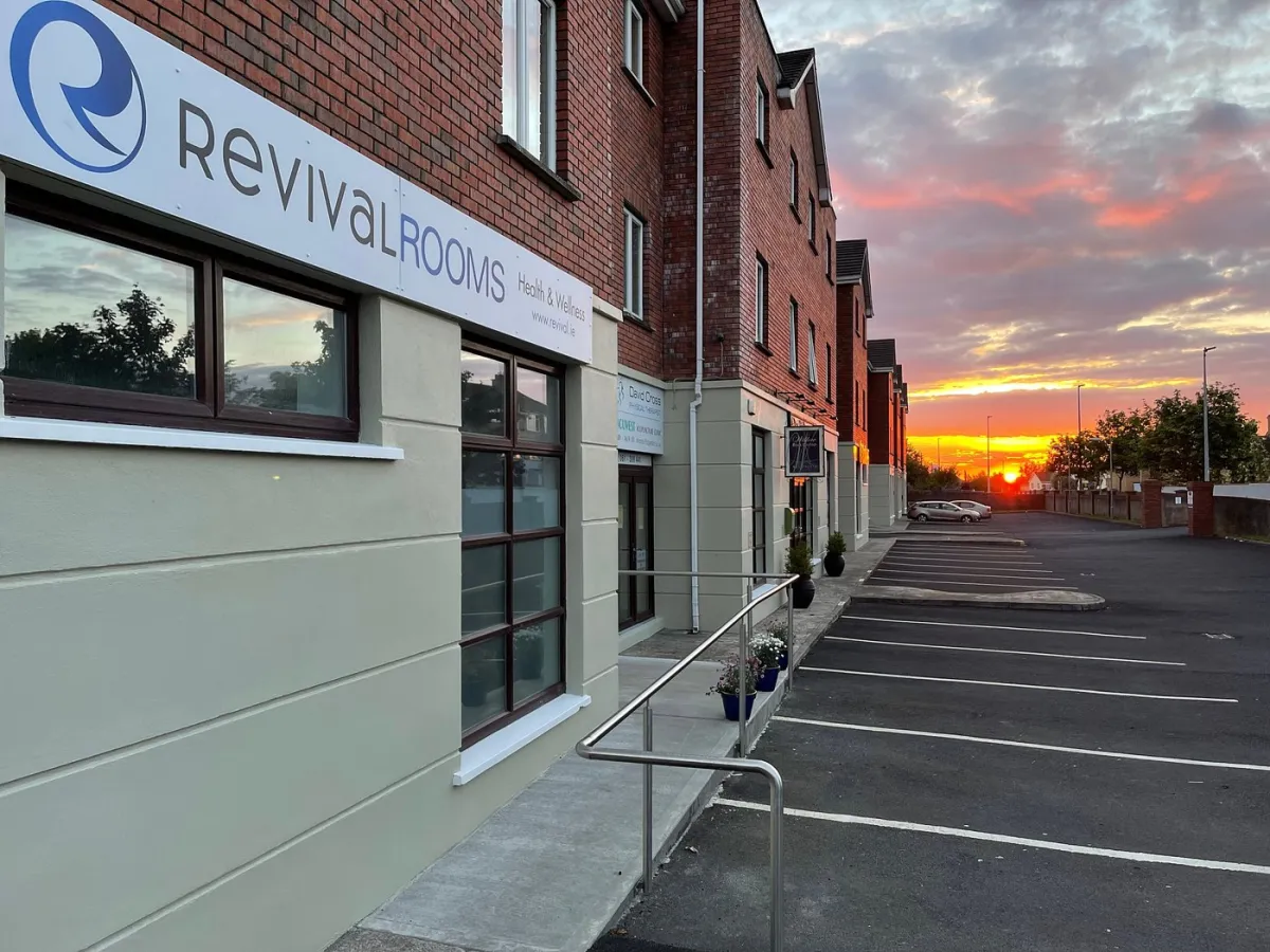 Building with Revival Rooms sign at sunset.