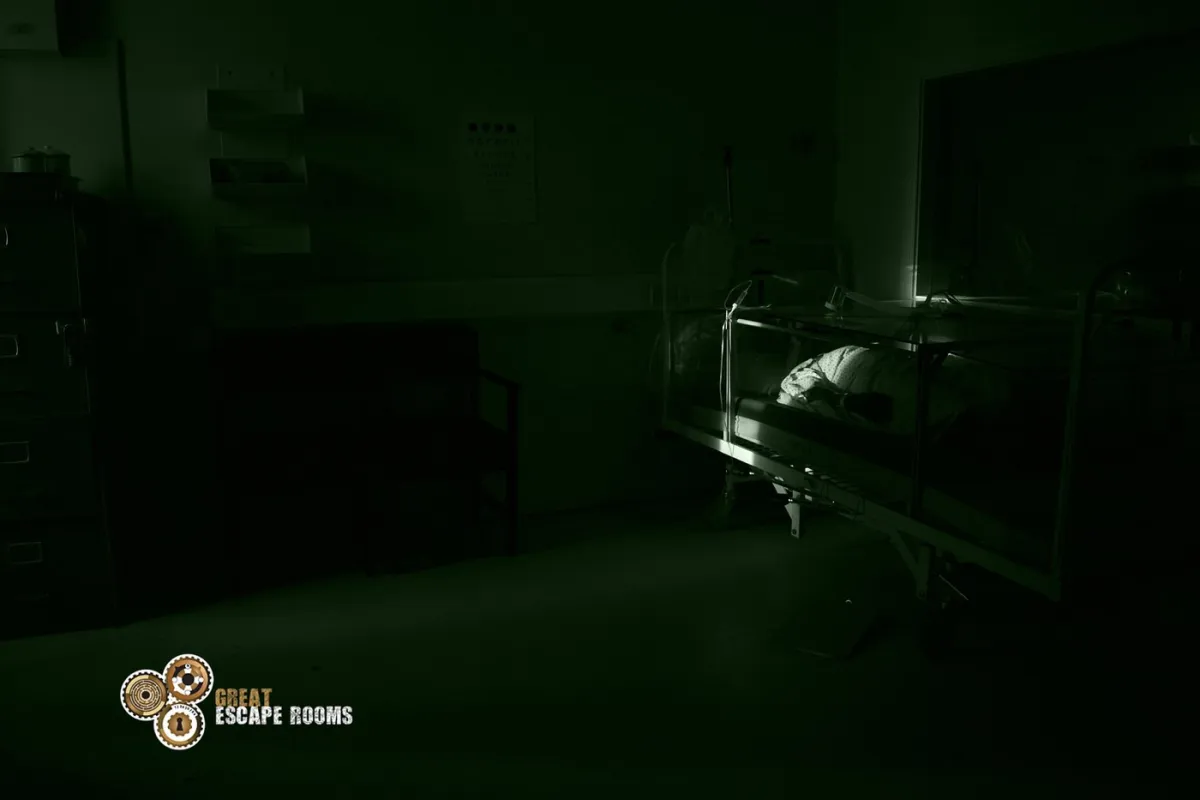 Dimly lit hospital room with a bed.
