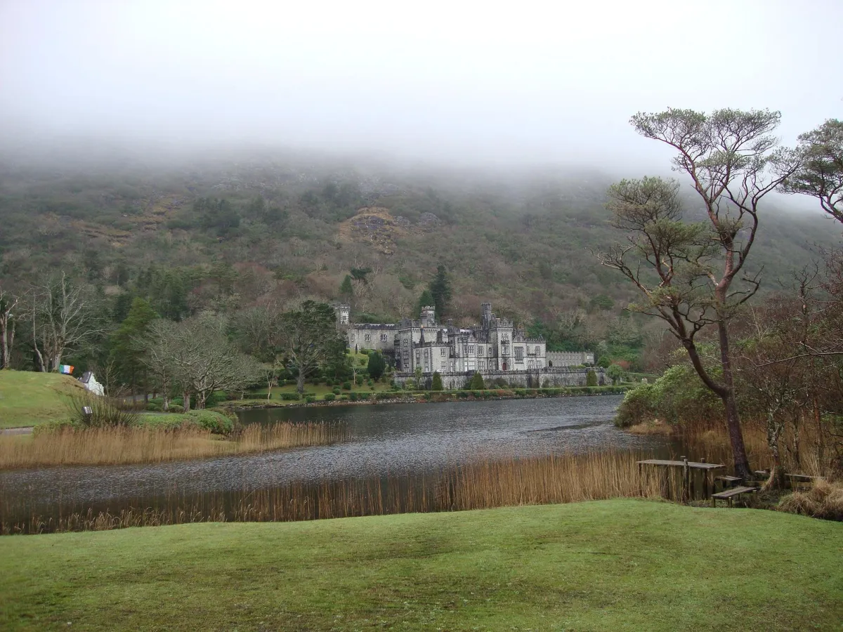 Castle by a lake with misty hills in the background