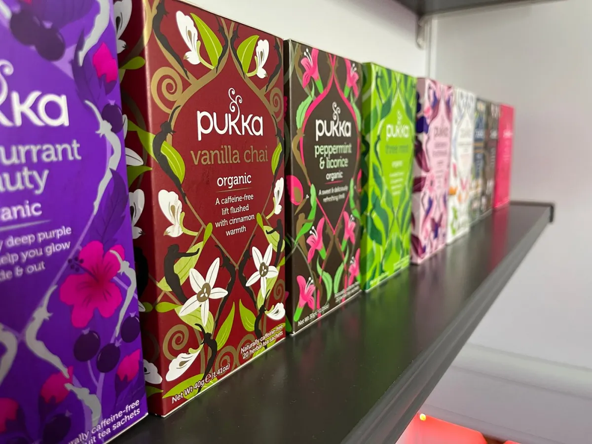 Assorted Pukka tea boxes on a shelf.