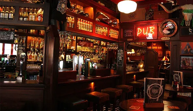 Interior of a cozy pub with a neon sign.