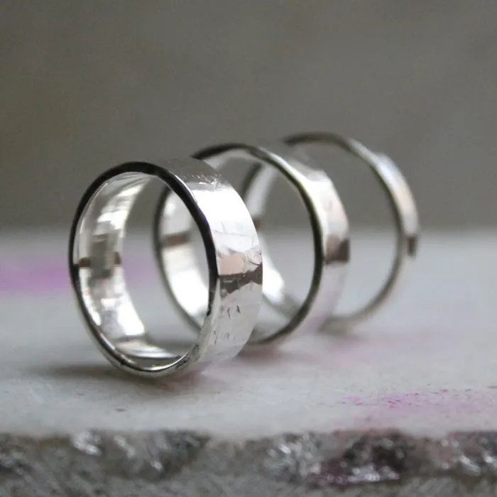 Three silver rings on a textured surface