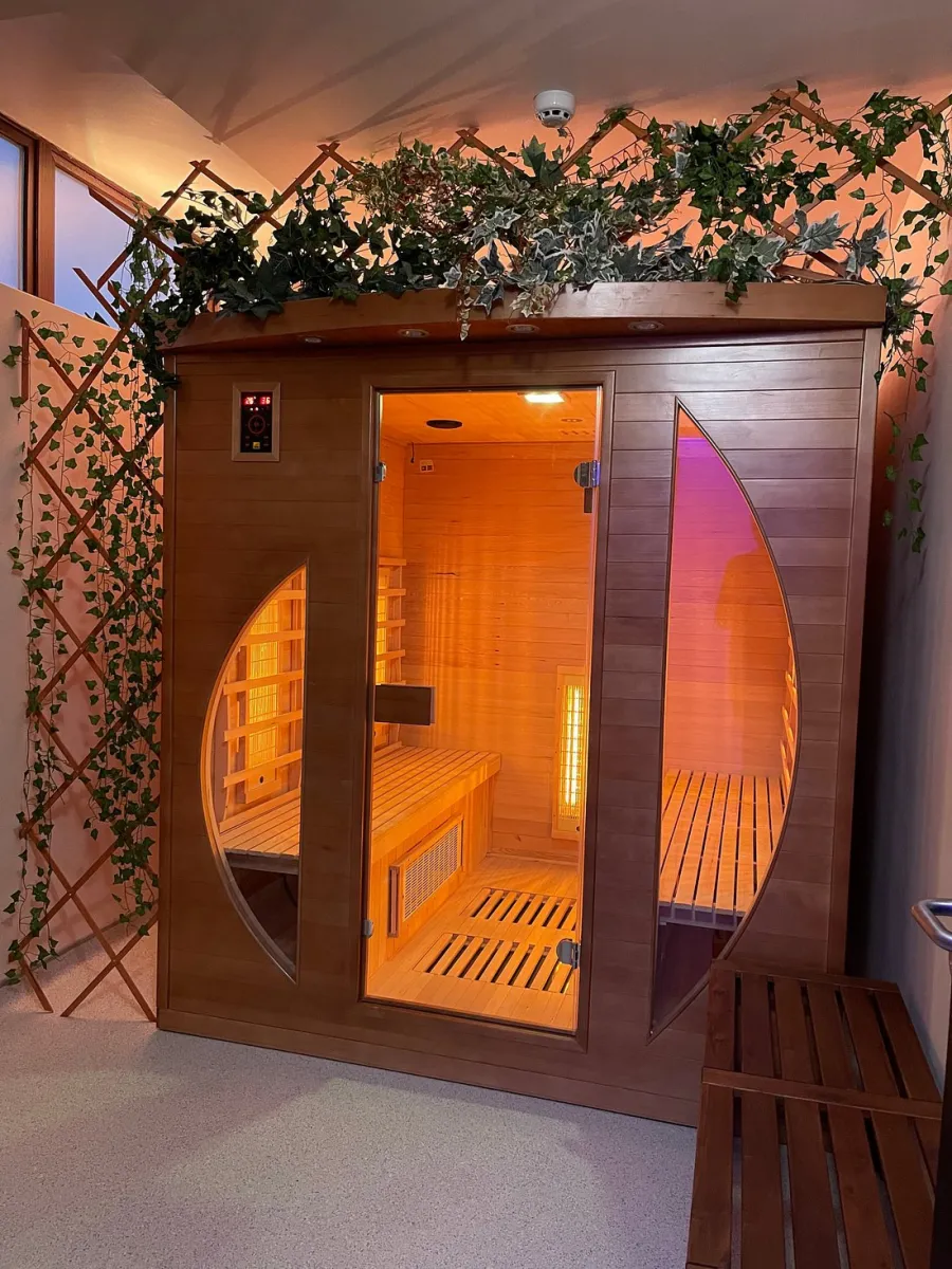 Wooden sauna cabin with plants on top