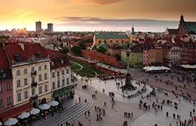 Aerial view of a historic city square at sunset.