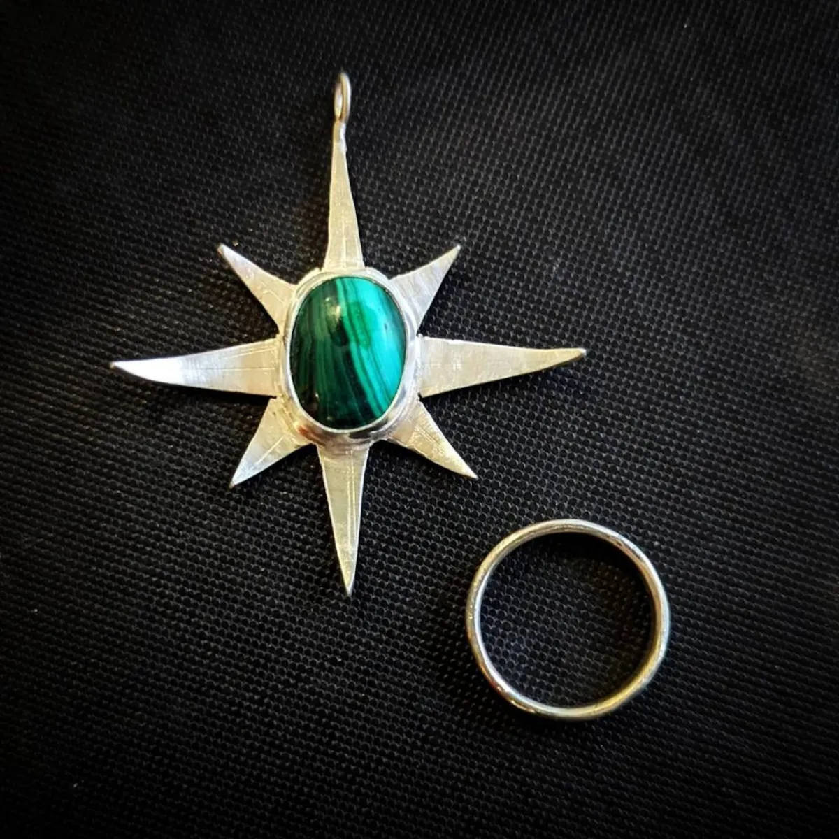 Silver star pendant with green stone and silver ring.