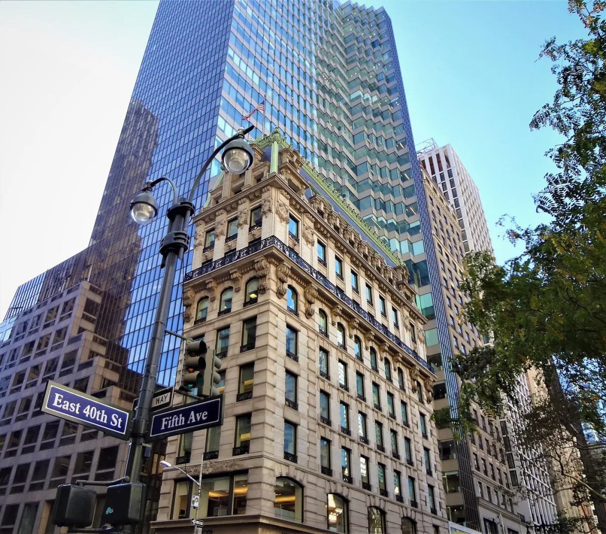 Street signs at East 40th St and Fifth Ave with tall buildings.