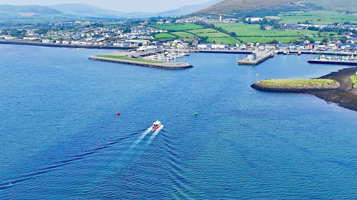 Aerial view of a coastal town with a boat in the water.