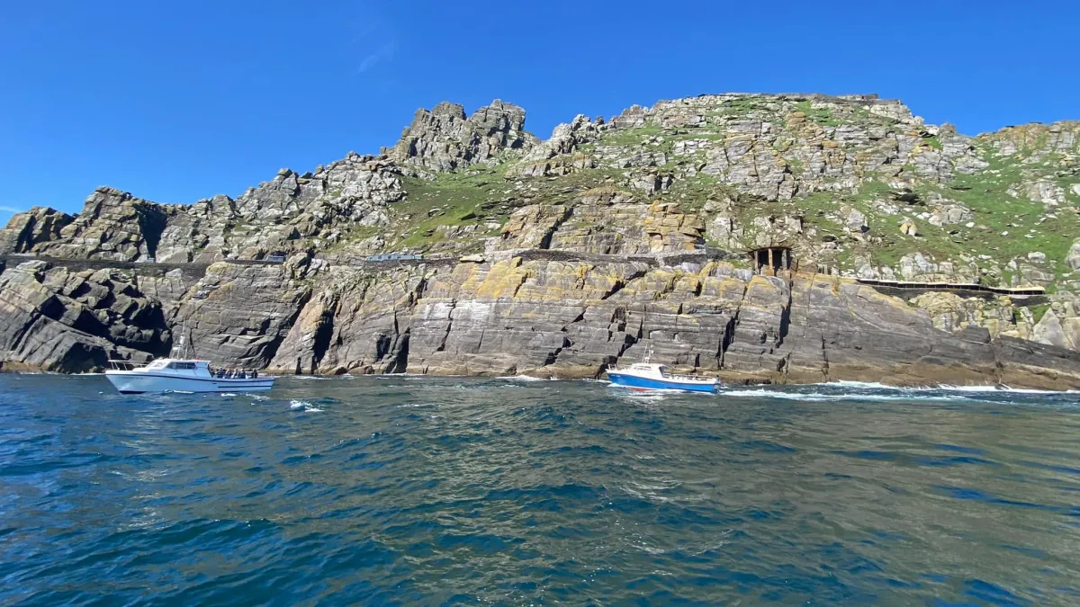 Tour boats cruising near the rocky cliffs of Skellig Michael in County Kerry