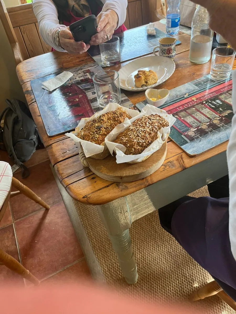Table with bread and a person using a smartphone
