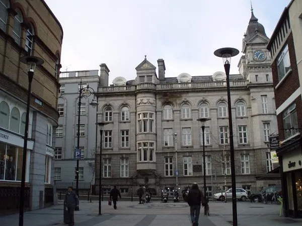 Historic building with clock tower in urban setting.