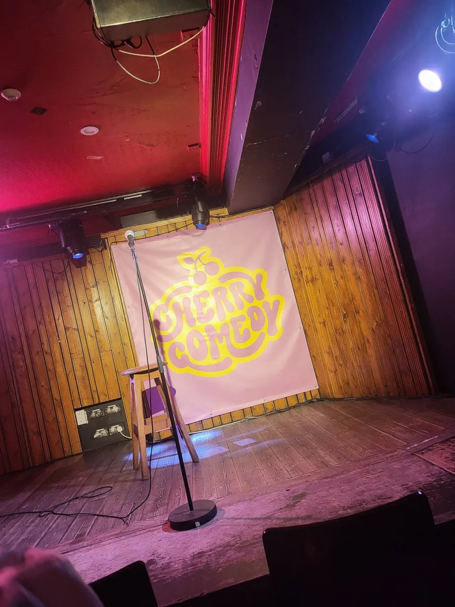 Empty comedy stage with microphone and stool.