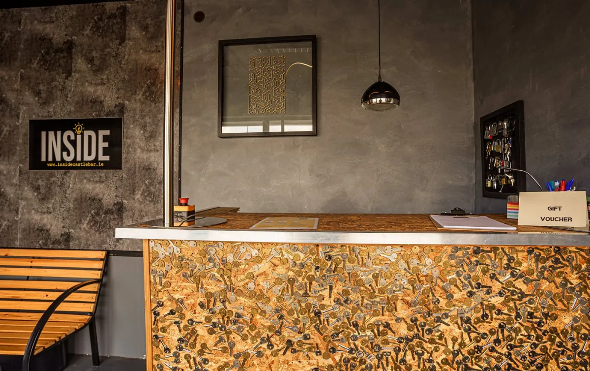 Reception desk with key-themed decor and gift voucher sign
