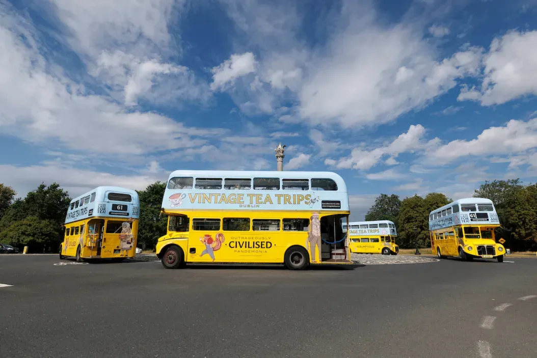 Four vintage double-decker buses in a circular formation.