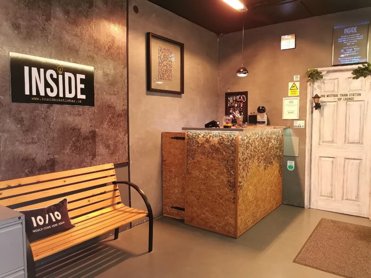 Interior of a themed reception area with bench and counter.