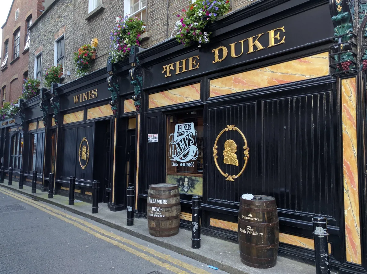 Exterior of The Duke pub with barrels and flowers.