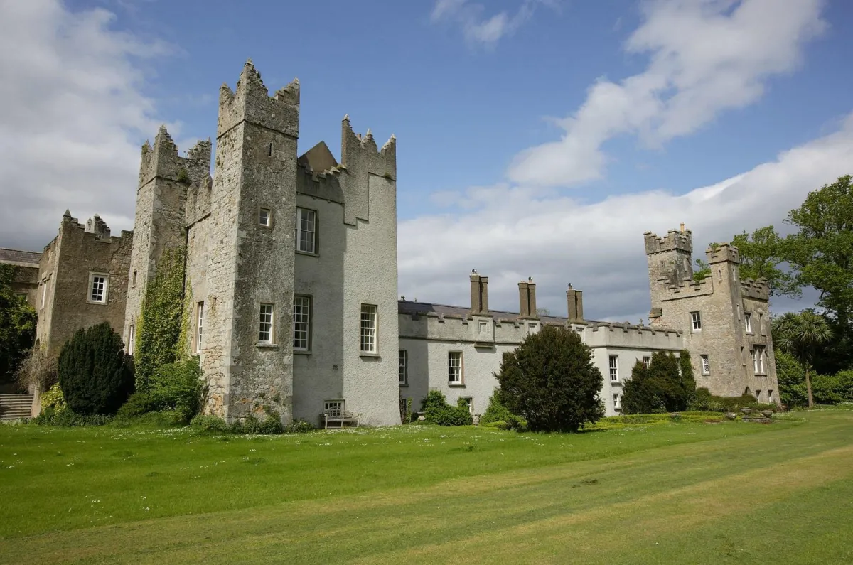 Historic stone castle with towers and green lawn